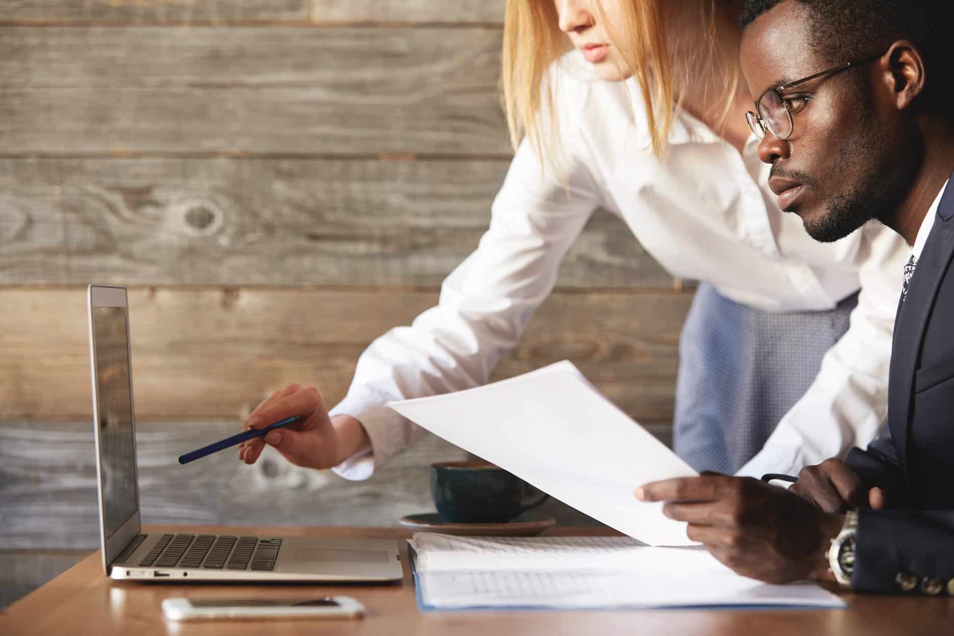 Business professionals analyzing financial data and tax planning for corporate tax and VAT in the UAE.