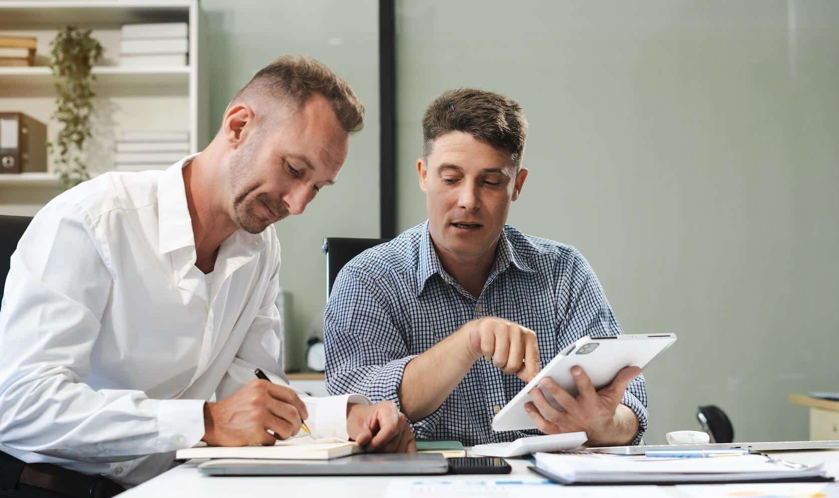 Finance team reviewing ERP systems, invoices, and VAT workflow data in an office setting.