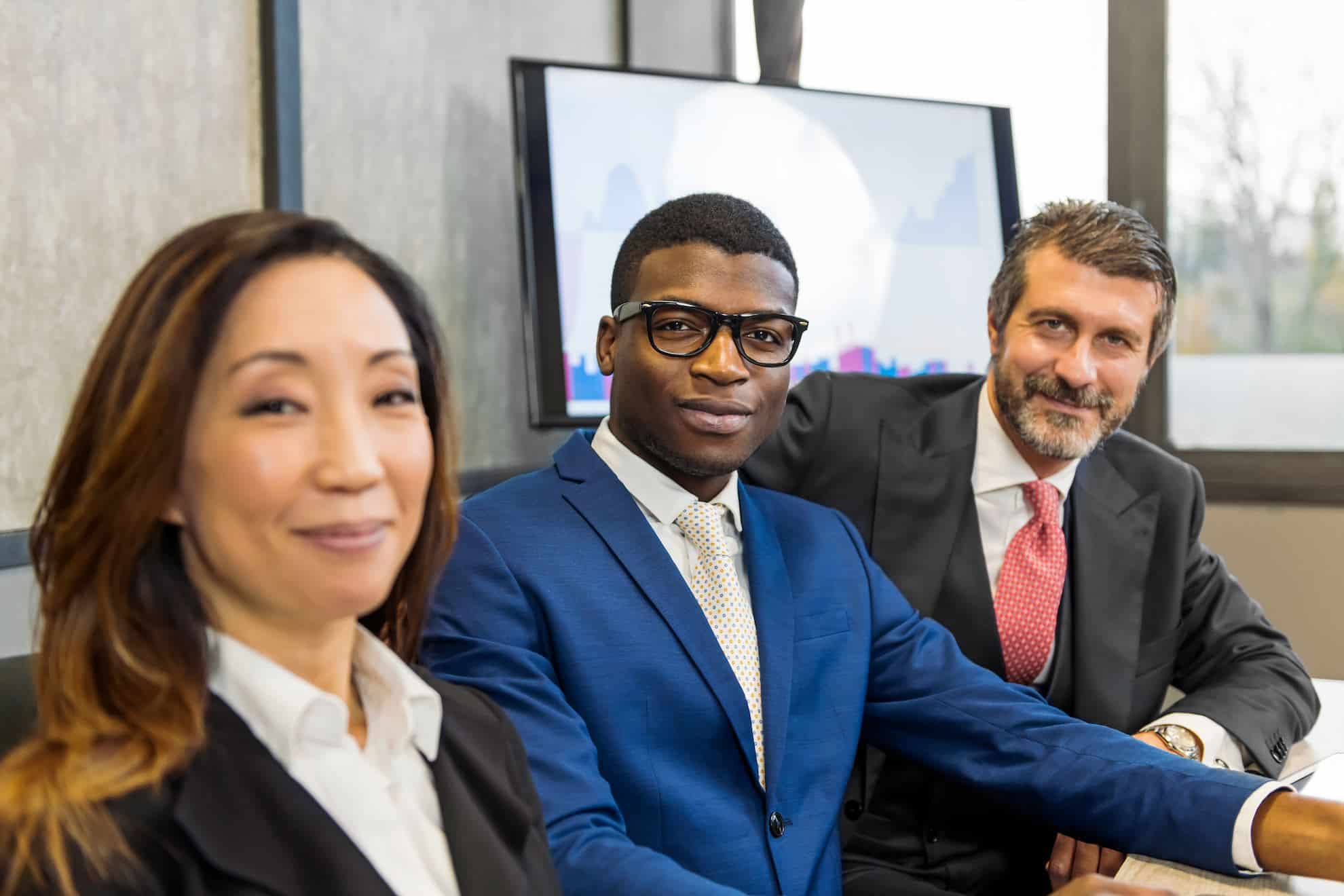 Three TaxReady.ae tax accountants posing in their high-end office for a photo.